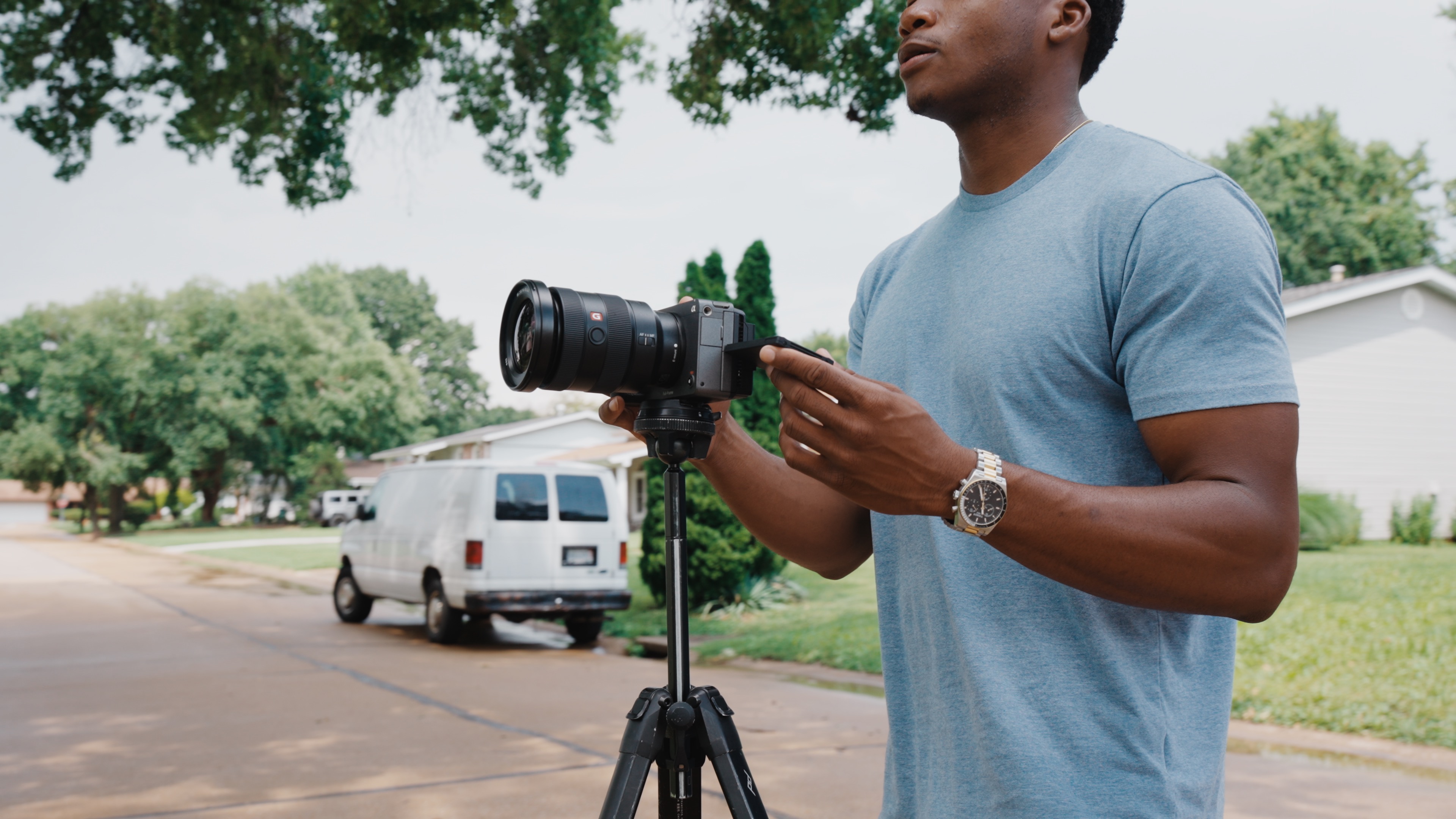 PropertyFlix videographer setting up a tripod shot in a residential driveway